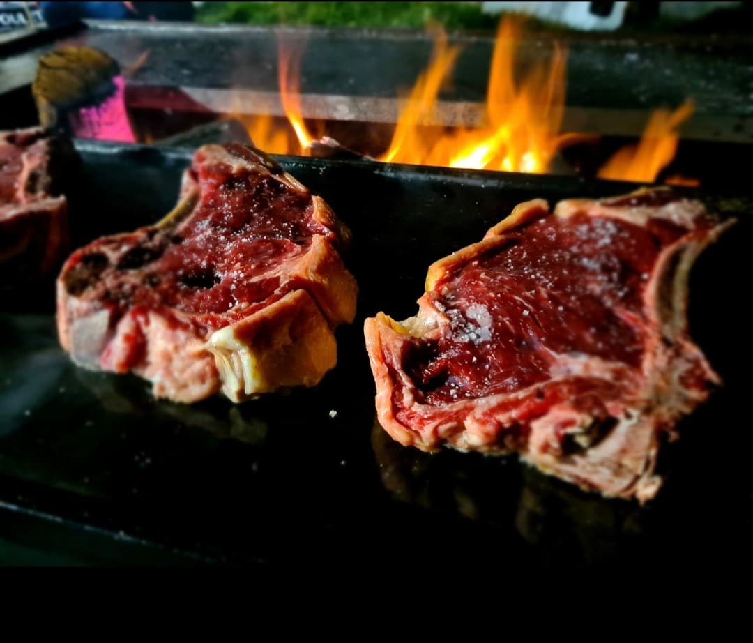 Côtes de bœuf sur le brasero, flamme derrière